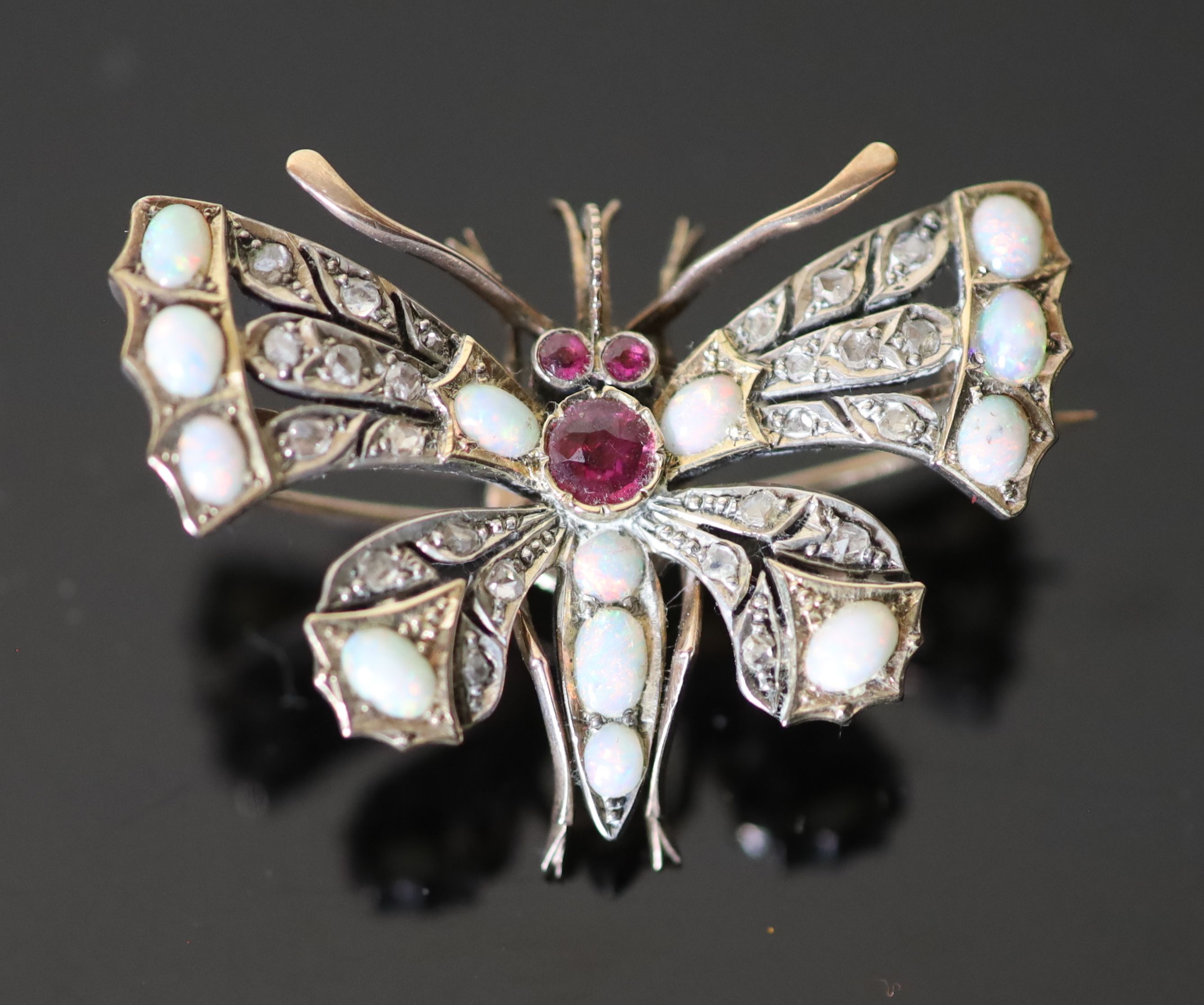 An Edwardian gold and silver, rose cut diamond, white opal and ruby set butterfly brooch,